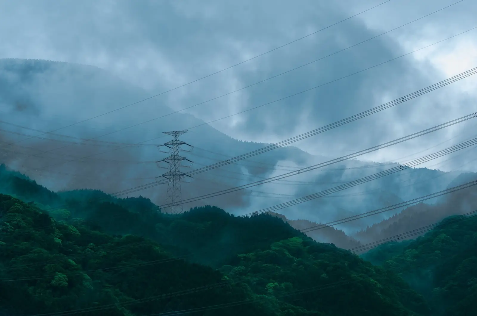 Lignes à haute tension et pylône dans la brume