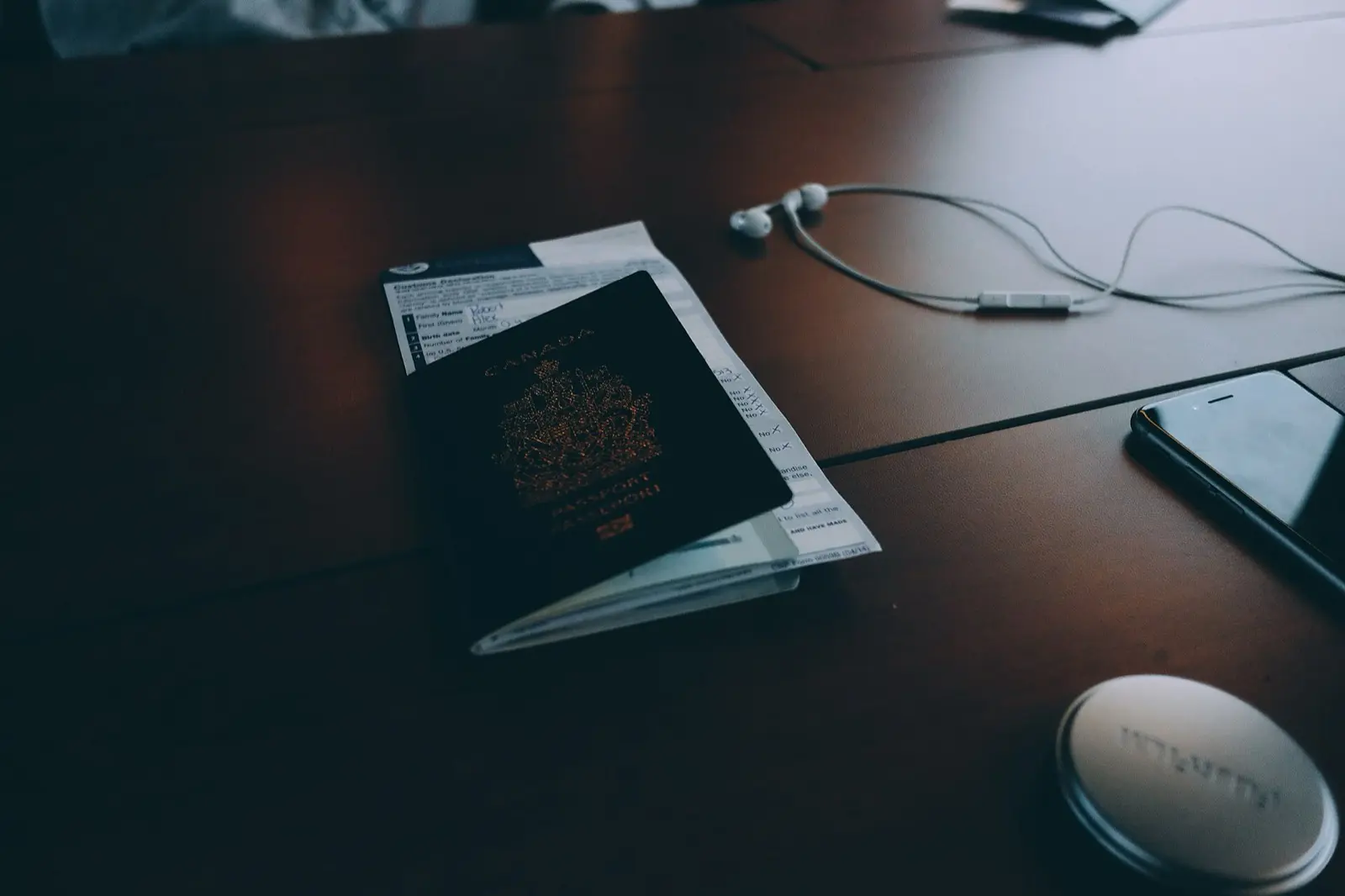 Documents et passeport posés sur un bureau, à côté d’un téléphone