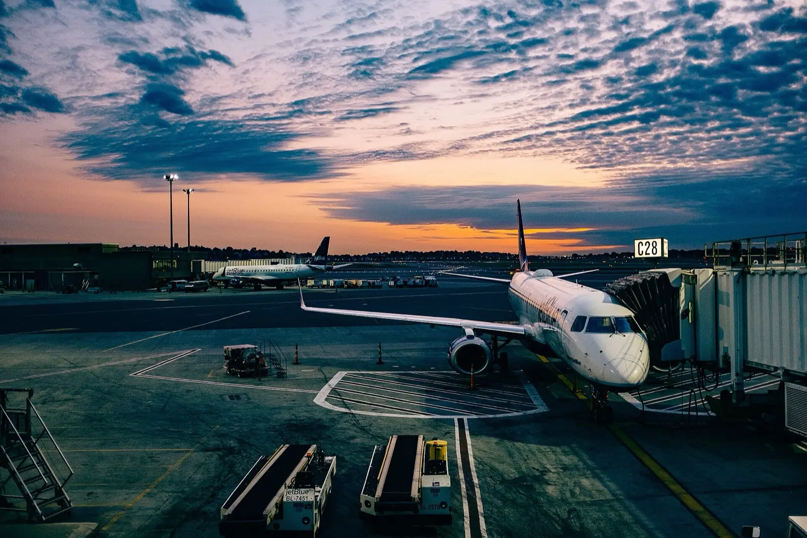 Avion stationné à la porte d’embarquement au coucher du soleil