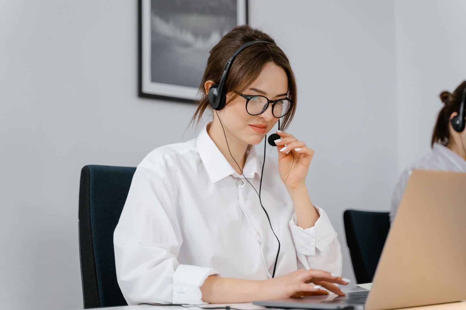 Conseillère du support en train de répondre, casque et ordinateur